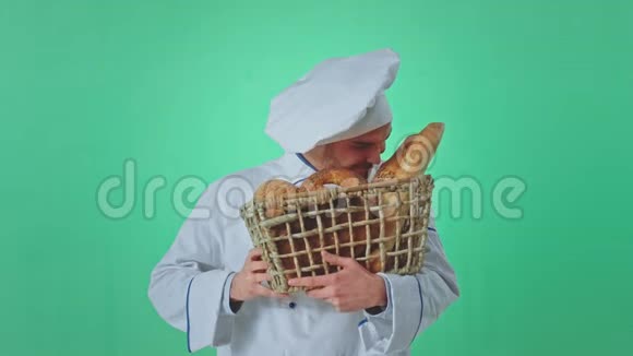 在镜头前面包师年轻人闻着新鲜的面包然后直视着镜头他在一个镜头里视频的预览图