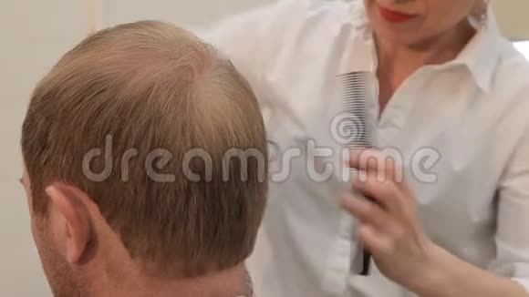 理发店里一个男人发型上的发型女性用手磨男人头部枕部视频的预览图