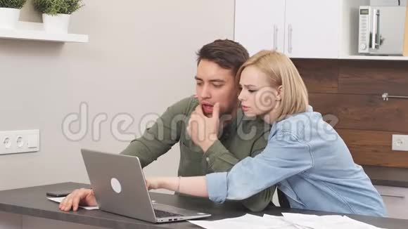 一对年轻的白种人夫妇在家里检查公用事业账单分析视频的预览图