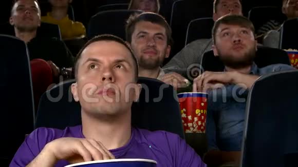 年轻人在电影院看电影惊悚片视频的预览图