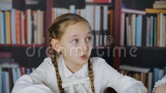 教室书架背景上的紧张女学生肖像班级里书架背景上的惊慌失措的女生视频的预览图
