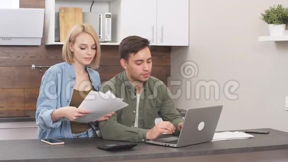 积极有趣的已婚夫妇用笔记本电脑检查家里的财务状况视频的预览图