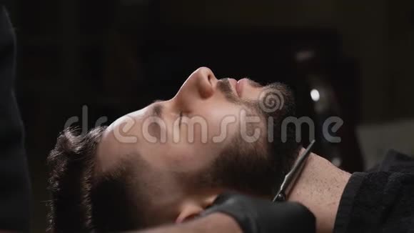 理发店梳胡须期间男性客户侧视视频的预览图