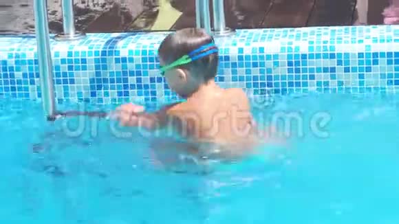 可爱的蹒跚学步的孩子在游泳池的水下跳跃在那里游泳视频的预览图