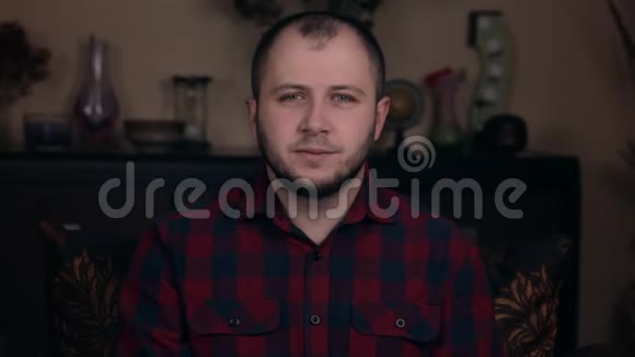 一个欧洲貌美的年轻人坐在椅子上穿着格子衬衫露出了一颗心爱的情感视频的预览图