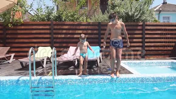 两个兄弟跳入游泳池玩得很开心家庭暑假的概念视频的预览图