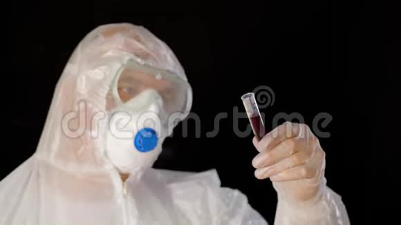 穿着防护服装的病毒学家呼吸器口罩和手套用血分析管流行病医生视频的预览图