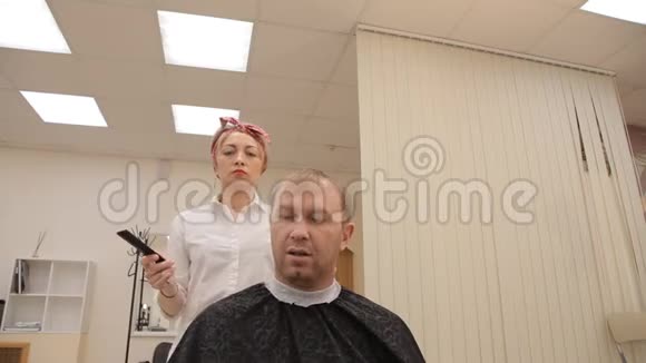 理发师和客户讨论寺庙的长度一个女孩带着红色的头带和红色的口红视频的预览图