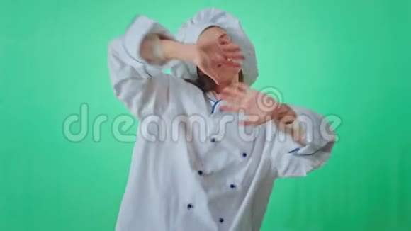 一个漂亮的面包师女人在绿色的工作室里跳舞微笑着在镜头前兴奋地享受着时光视频的预览图