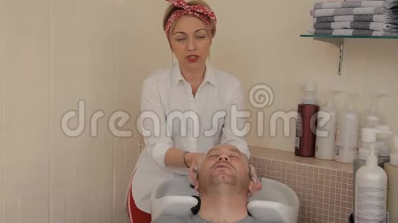 年轻的女理发师头上绑着绷带用针扎的方式洗头发然后把男人剪下来视频的预览图