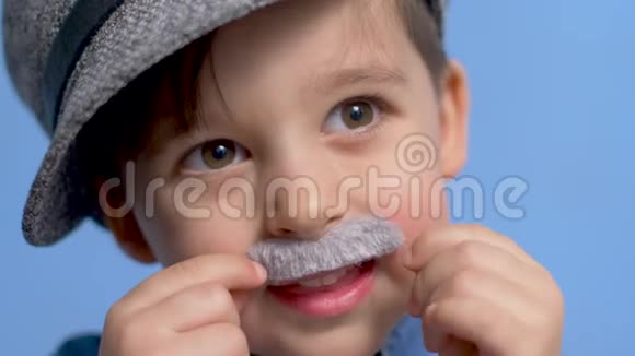 一个留着灰色胡子头发灰白戴着帽子的孩子站在蓝色的背景上视频的预览图