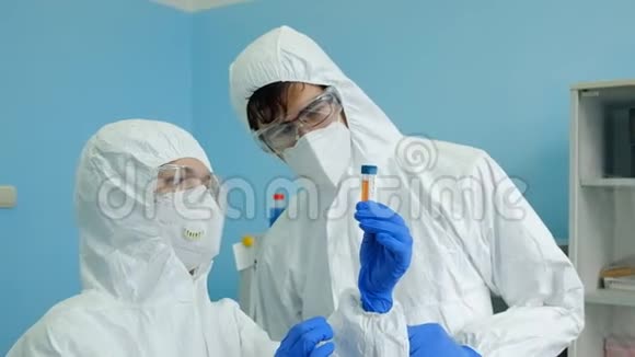 科学家病毒学家和生物学家一男一女在实验室里讨论试管中的成品疫苗视频的预览图