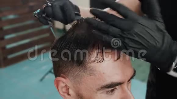理发师的手在美容院剪湿了男性的头发理发店用剪刀和梳子给男性理发视频的预览图