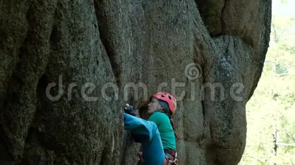 一位年轻女子在一面垂直的墙上爬上一条艰难的路线视频的预览图