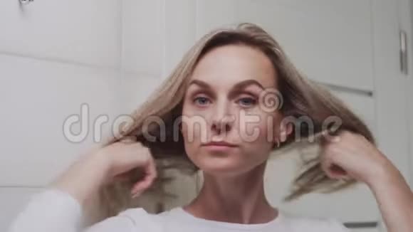女人在眼睛下面涂上奶油看着镜头视频的预览图