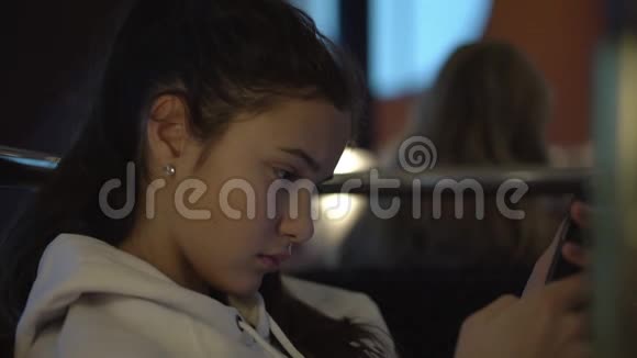 女孩坐在咖啡馆里在旅途中使用电话上网视频的预览图