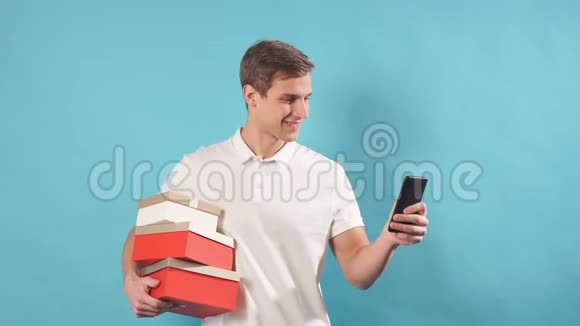 一个年轻的快递男孩穿着白色T恤手里拿着盒子的肖像视频的预览图