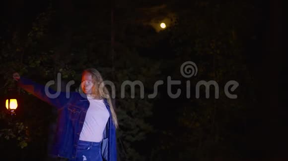 夜空中满月的可怕森林里拿着煤油灯的年轻女子油灯惊魂女视频的预览图