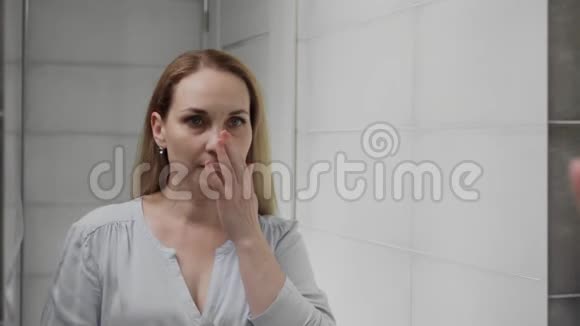 沮丧的成年人在浴室镜子里看着她的脸视频的预览图