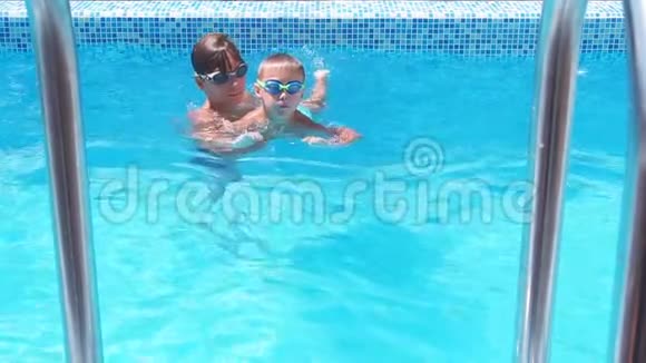孩子和弟弟一起在游泳池里度过时光学会在游泳池里游泳慢动作视频的预览图