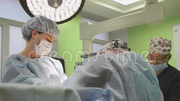 手术期间的手术团队外科医生是一个友好的团队蓝色现代手术室的专业人士视频的预览图