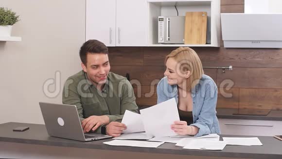 美丽的年轻丈夫与微笑的幸福妻子讨论合同细节的财务问题视频的预览图
