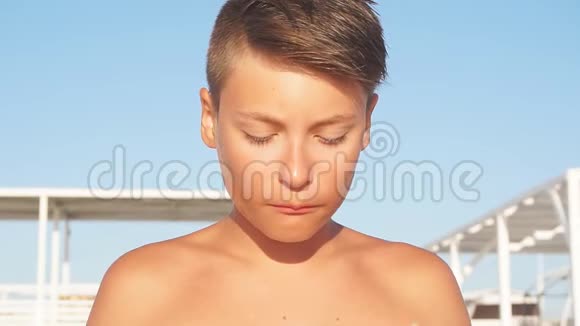 十几岁的男孩坐在沙滩椅上吃切片西瓜夏日特写视频的预览图