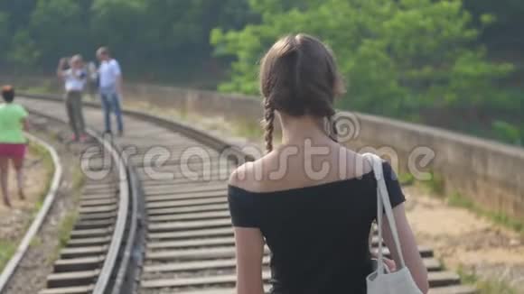 女孩沿着桥上的小路散步到游客拍照视频的预览图