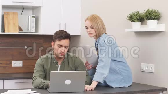 年轻的白种人配偶坐着现代笔记本电脑和文件视频的预览图