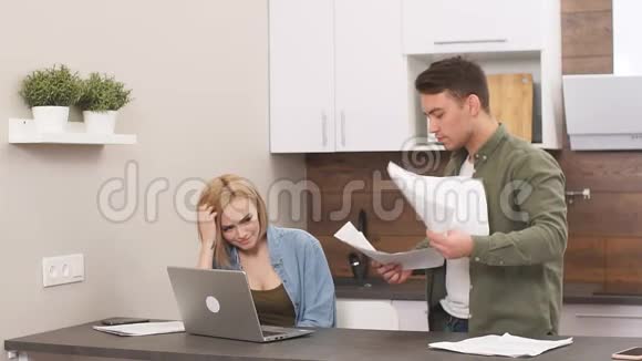 失望的悲伤的一对夫妇在家里为金融而烦恼坐着笔记本电脑和文件视频的预览图