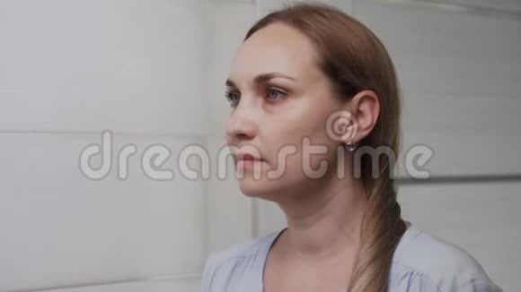 一个沮丧的成年女人在浴室的镜子里看着她的脸视频的预览图