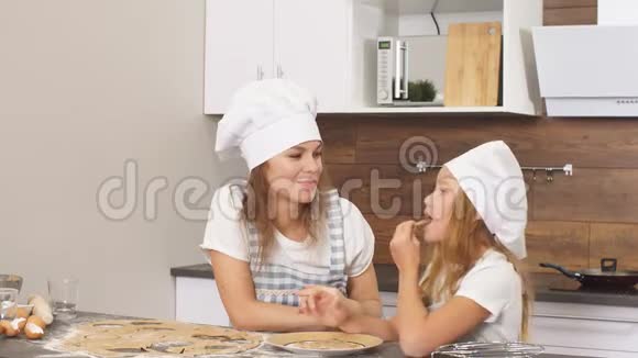 家庭观念年轻的白种人母亲教她的孩子烘焙烹饪视频的预览图