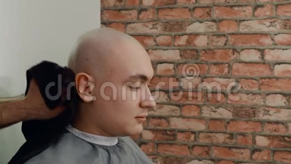 关闭理发师用毛巾擦拭客户头部的视野视频的预览图