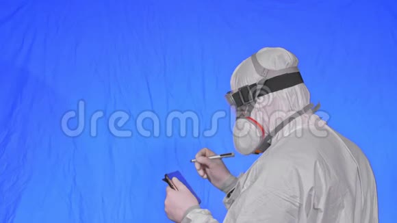 科学家病毒学家在呼吸器上用手写笔在平板电脑上写字戴防护口罩的男子视频的预览图