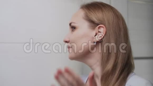 靠近优雅的年轻女子看着镜子在浴室里摸着她的脸视频的预览图