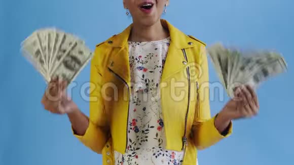 满意快乐兴奋的非洲裔美国妇女在蓝色背景上展示金钱和说上帝的上帝视频的预览图