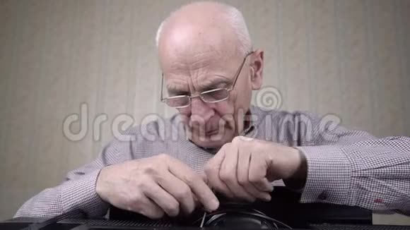 戴眼镜的老人用螺丝刀拧下黑色牛仔帽视频的预览图