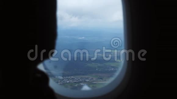 在飞行过程中乘客人从飞机窗口座位观看美丽的空中景观景观的特写剪影视频的预览图