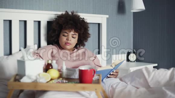 生病的非裔美国女孩躺在床上用电话制作视频或故事视频的预览图