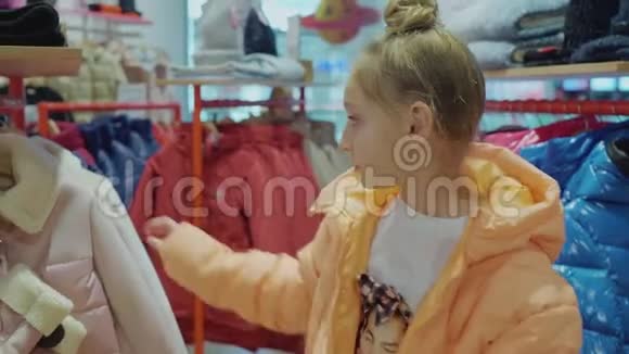 快乐女孩在时装精品店试穿时尚粉色夹克视频的预览图
