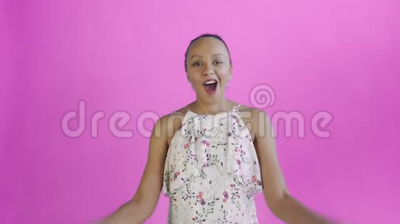 心满意足的美籍非洲裔妇女兴奋地拿出钱在粉色的背景下说我的上帝白色连衣裙视频的预览图
