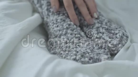 穿着温暖袜子的女人用手牵着她的腿关门视频的预览图