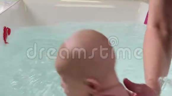 在游泳池里的游泳课上父亲帮助的是婴儿视频的预览图