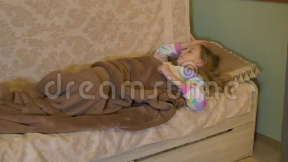 可爱的小女孩躺在床上醒来视频的预览图