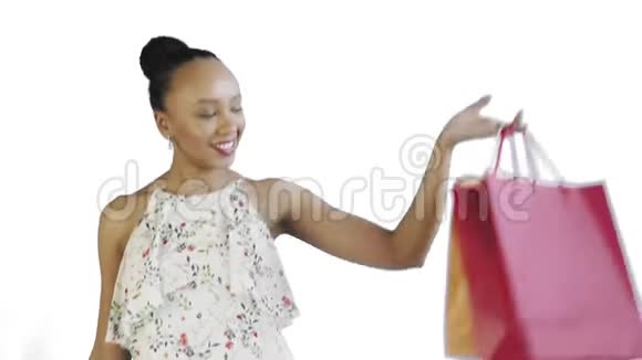 非裔美国妇女正在工作室的白色背景上摆着购物袋喜妇视频的预览图