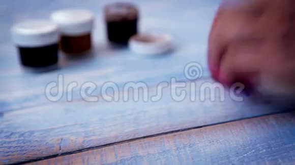 艺术家用海绵在木板上画画的慢镜头视频的预览图