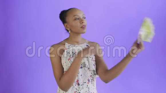 体贴成功的非裔美国妇女紫色背景有钱带花的白色连衣裙视频的预览图