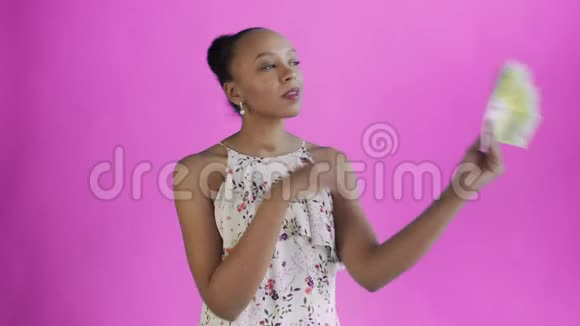 体贴成功的非洲裔美国妇女有钱的粉红色背景带花的白色裙子视频的预览图