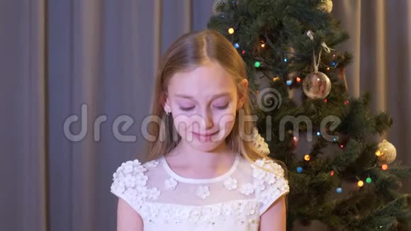 站在圣诞树旁的漂亮的伤心女孩在室内哭泣视频的预览图