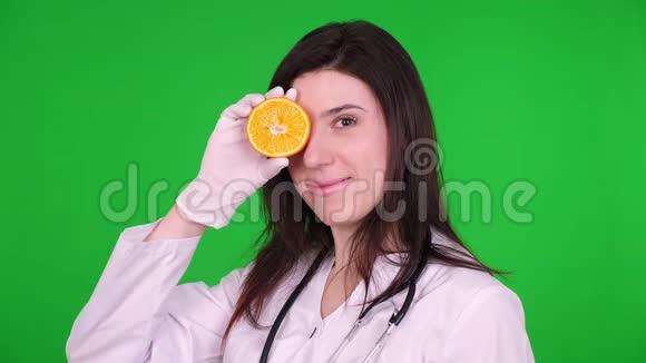 年轻女医生的肖像营养学家穿着白色的医疗制服用听诊器拿着两半视频的预览图